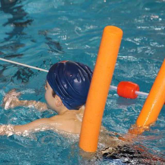 Kind ein Schwimmunterricht mit Schwimmnudel
